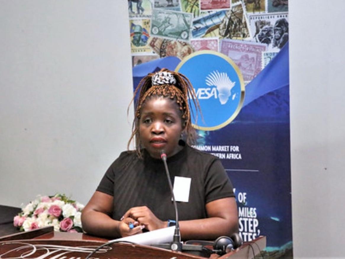 A portrait of Bonakele speaking into a microphone