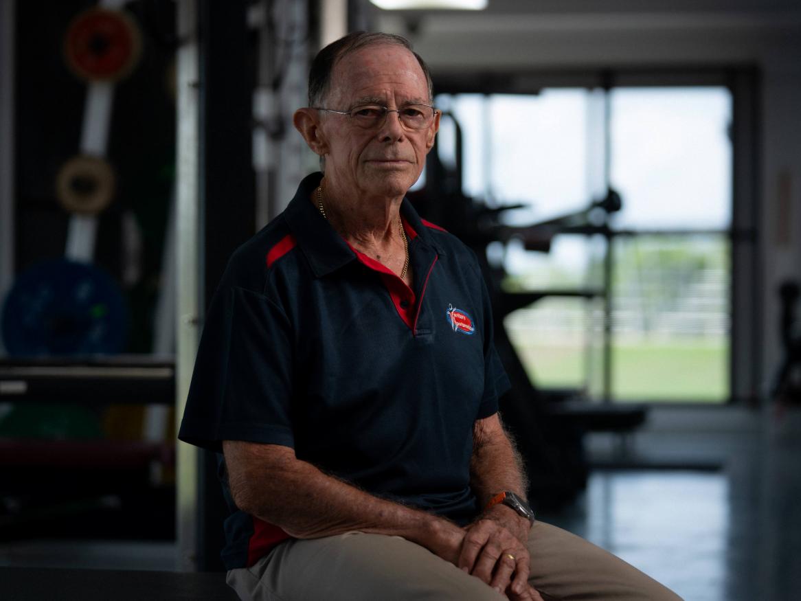 A photo of Geoff sitting in a gym  