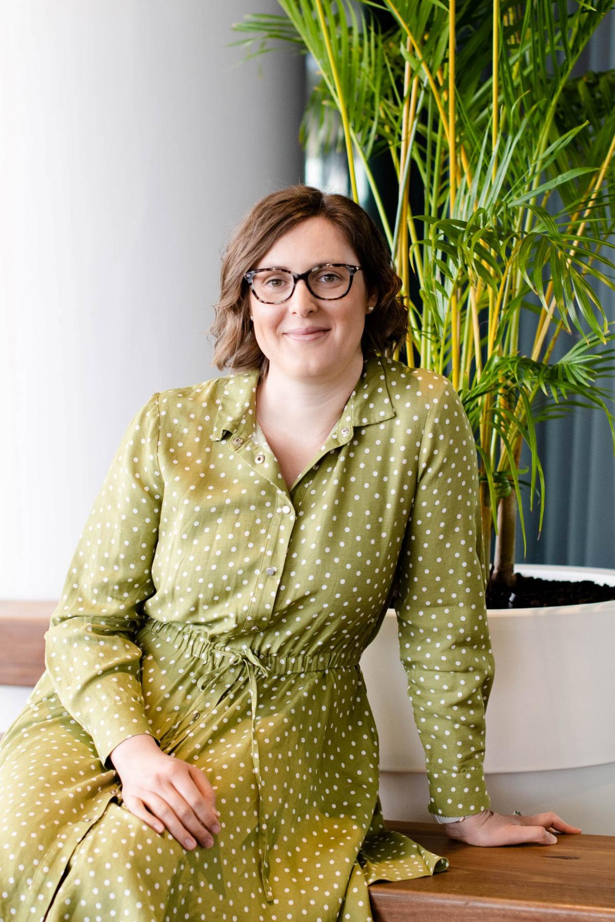A photo of Elise sitting down in a green dress