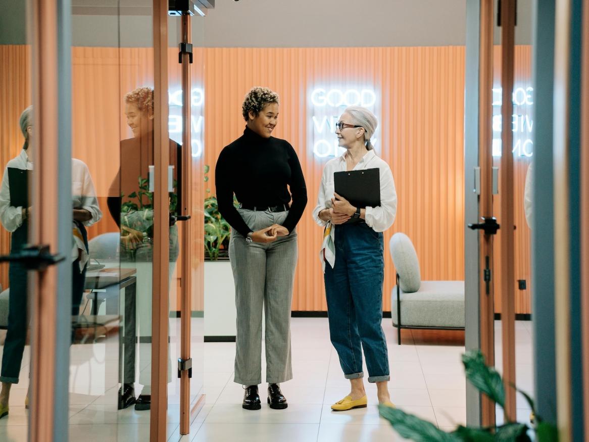 Two women talking in corridor