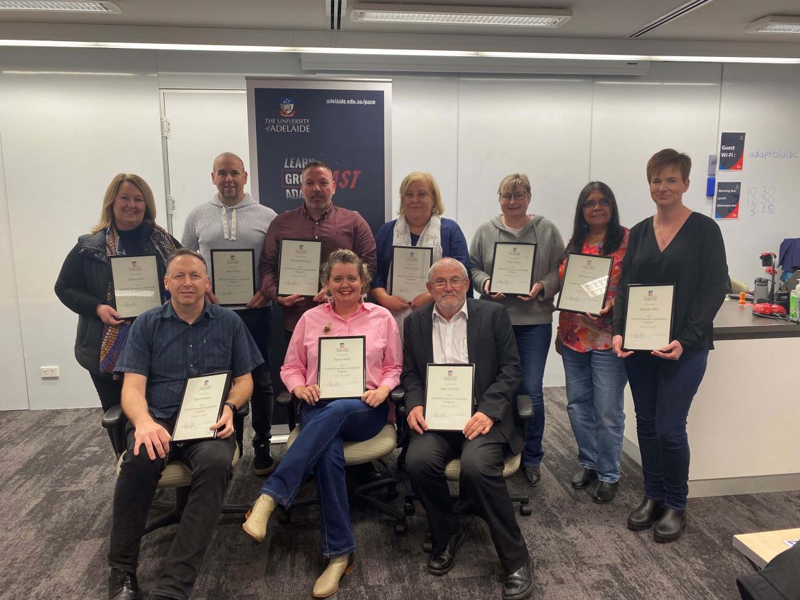 A group of students holding their completion certificates