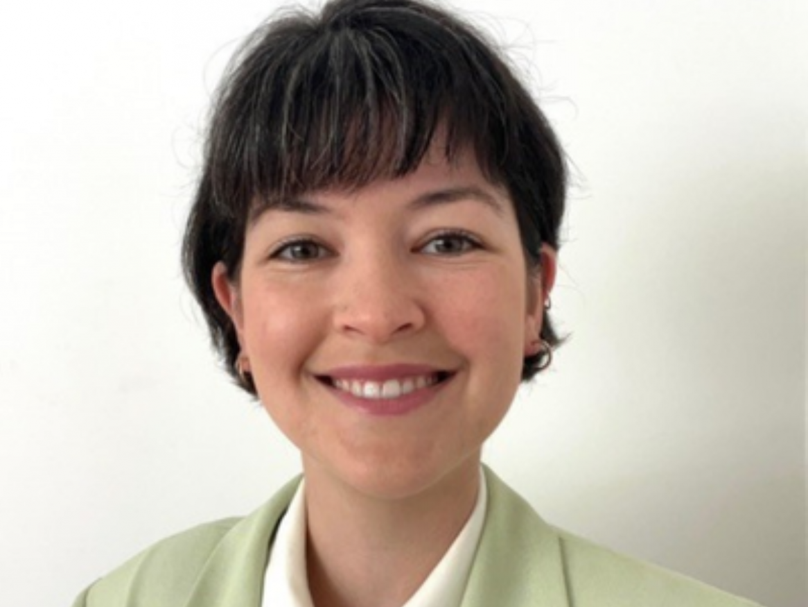 A photo of Dr Nolan smiling in a green blazer